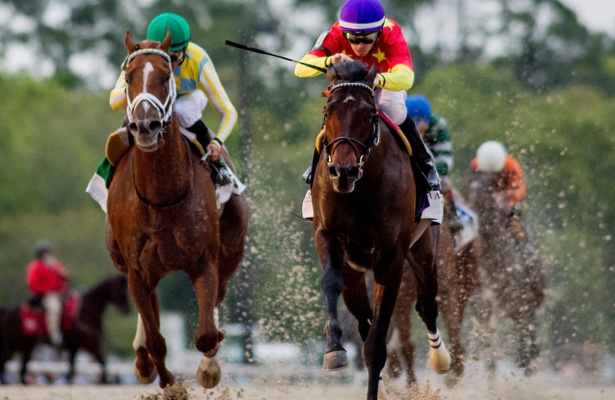 Dynamic horse race featuring jockeys in colorful silks, showcasing speed and competition on a dirt track.