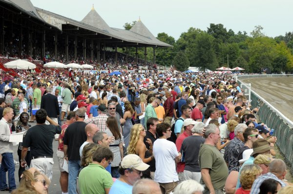 Large crowd gathered at a horse racing event, showcasing enthusiastic spectators enjoying the races and social atmosphere.